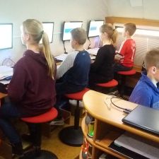 Kinderen zitten achter computers en krijgen les in de Typejuf caravan